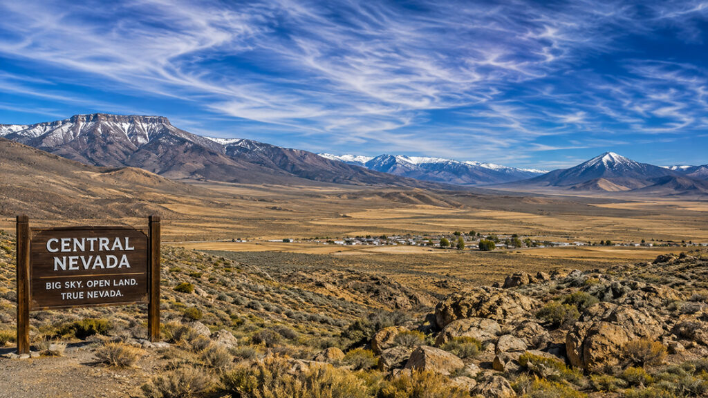 Scenic Central Nevada landscape with open desert plains, rugged mountain ranges, and a sign reading “Central Nevada — Big Sky. Open Land. True Nevada.”